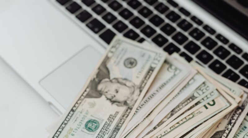 Dólares sobre um notebook, representando o mercado financeiro